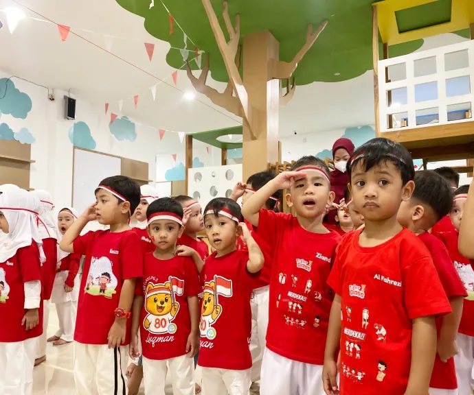 Anak berbaju merah memberi hormat saat peringatan nasional