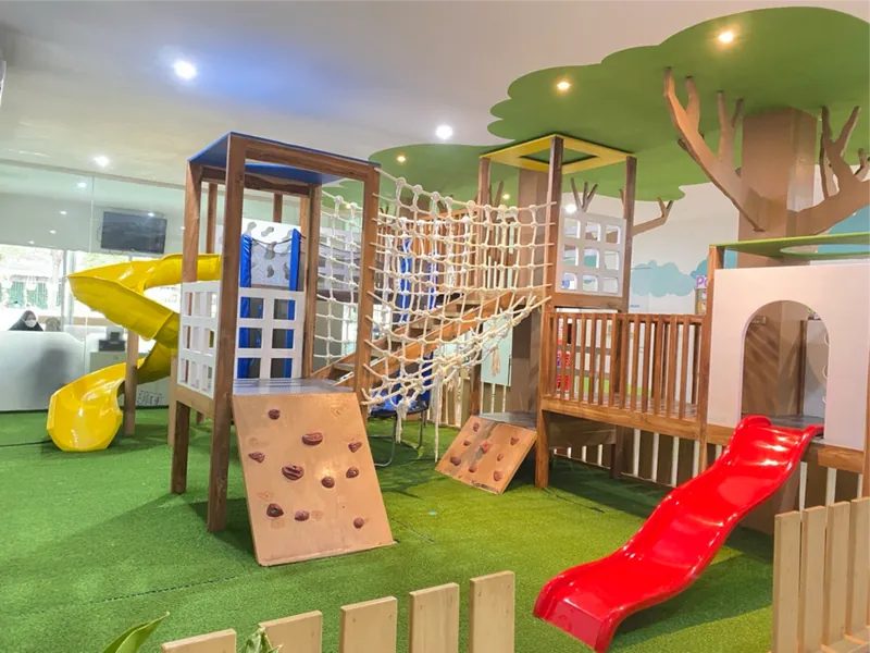 Playground dengan jaring, seluncuran, dan dinding panjat