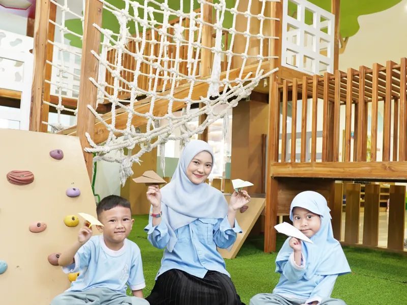 Guru dan anak-anak Early Years bermain bersama di area playground