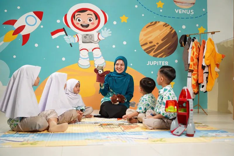 Guru bercerita dengan boneka tangan kepada anak-anak Kindergarten di kelas bertema luar angkasa