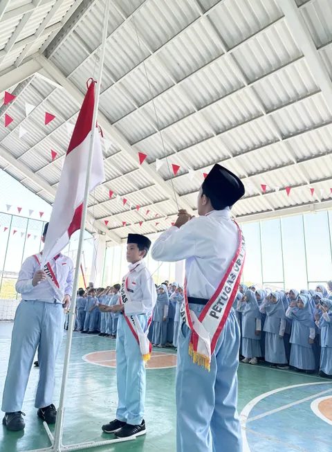 Siswa mengibarkan bendera saat upacara peringatan nasional