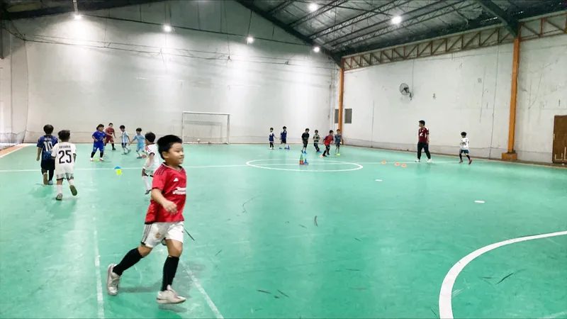 Siswa bermain futsal di lapangan dalam ruangan