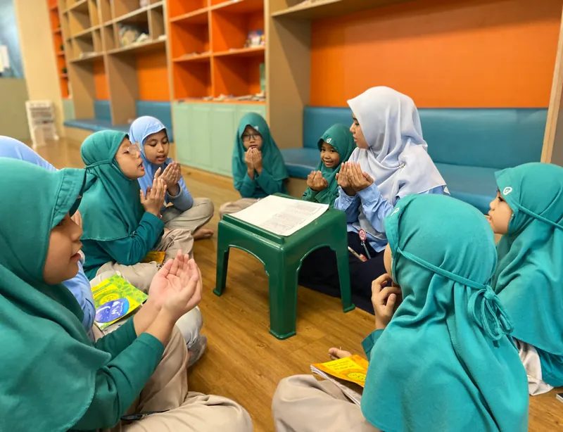 Guru membimbing siswi membaca Al-Qur'an dalam halaqah