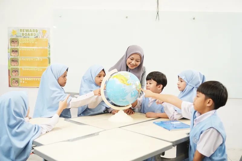 Guru dan siswa belajar dengan globe