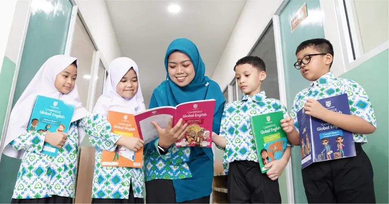 Guru dan siswa membaca buku Cambridge