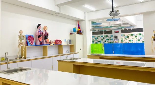 Laboratorium sekolah dengan meja kerja dan peralatan sains