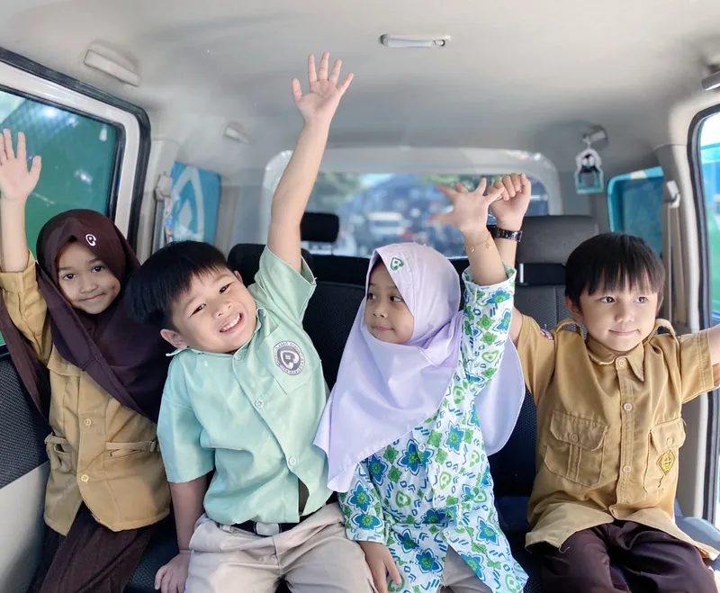 Anak-anak ceria di dalam mobil antar-jemput